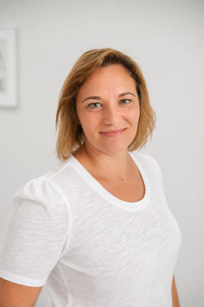 Lisa Mezger Therapeutin im Therapiezentrum Pro, lächelt freundlich in die Kamera, weißes T-Shirt