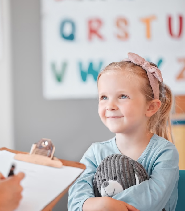 Kleines Mädchen mit rosa Haarband und Kuscheltier bei einer psychologischen Sitzung im VTherapeutin im Therapiezentrum Pro