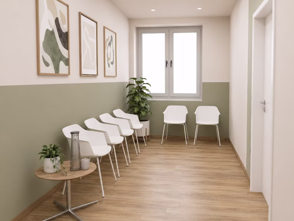 Moderner Wartebereich bei Vitanium Therapiezentrum Pro mit weißen Stühlen, Holzboden und grüner Wandgestaltung